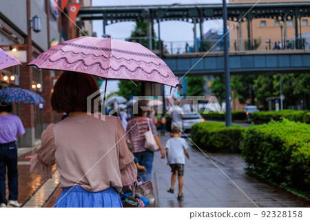 People walking with an umbrella on a rainy day 92328158