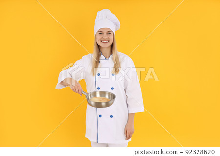 Concept of cooking with young woman on yellow background 92328620