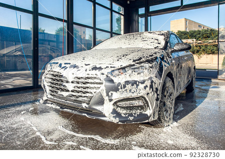 The car, doused with foam, is located in the self-service car wash section. The car, doused with foam, is located in the self-service car wash section. 92328730