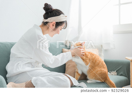 Japanese woman holding a cat at home (pet / owner) Japanese woman holding a cat at home (pet / owner) 92329026