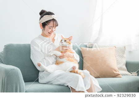 Japanese woman holding a cat at home (pet / owner) 92329030