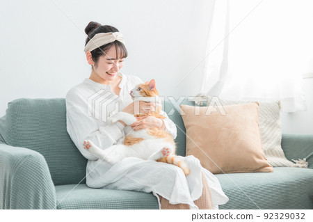Japanese woman holding a cat at home (pet / owner) 92329032