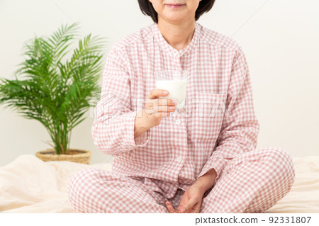 臥室裡穿著睡衣喝牛奶的中產婦女 臥室裡穿著睡衣喝牛奶的中產婦女 92331807