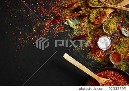 Assorted spices on dark black background. Seasonings for food. Curry, paprika, pepper, cardamom, turmeric. Top view. Assorted spices on dark black background. Seasonings for food. Curry, paprika, pepper, cardamom, turmeric. Top view. 92332895