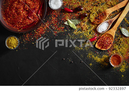 Assorted spices on dark black background. Seasonings for food. Curry, paprika, pepper, cardamom, turmeric. Top view. Assorted spices on dark black background. Seasonings for food. Curry, paprika, pepper, cardamom, turmeric. Top view. 92332897