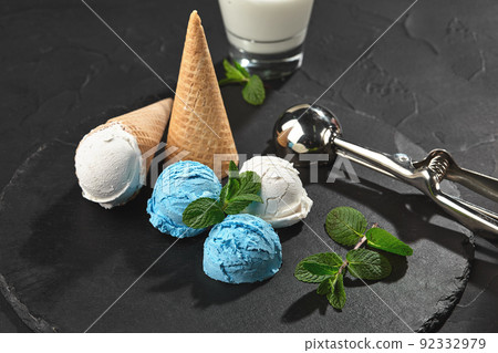 Close-up shot of a creamy and blueberry ice cream served on a dark slate, black background. Close-up shot of a creamy and blueberry ice cream served on a dark slate, black background. 92332979