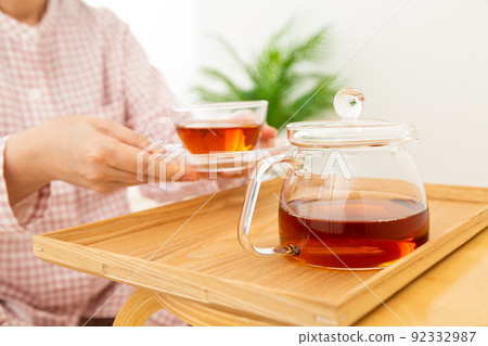 Middle-aged woman in pajamas drinking iced tea in the bedroom 92332987