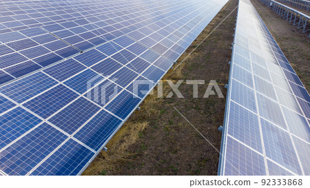 Aerial drone view flight over solar power station panels. Aerial top view of solar farm. Green energy, electrical innovation. Renewable Energy. Industrial Solar Energy Farm producing solar power. Aerial drone view flight over solar power station panels. Aerial top view of solar farm. Green energy, electrical innovation. Renewable Energy. Industrial Solar Energy Farm producing solar power. 92333868