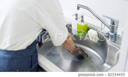 Woman cleaning drains (housework / housewife) 92334455