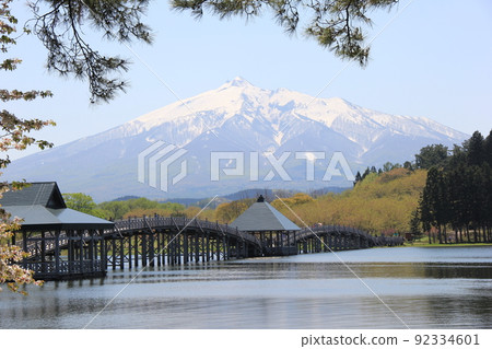 A landscape where "Tsuru no Maihashi" is built over "Mawarizeki Otameike (Lake Tsugaru Fujimi)" and "Mt. Iwaki (Tsugaru Fuji)" covered with snow can be seen in the back. 92334601