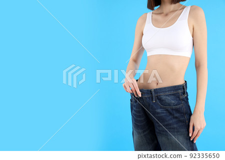 Concept of weight loss with young slim woman on blue background 92335650