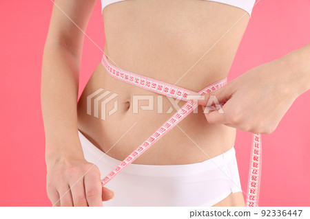 Concept of weight loss with young slim woman on pink background 92336447