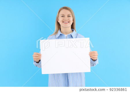 Woman holds blank banner on blue background 92336861