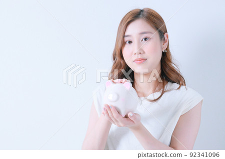 有存錢罐的年輕女人 | 看著相機 92341096
