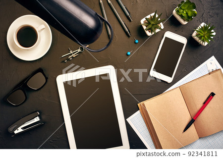 Engineer's desk in office with various gadgets and documents Engineer's desk in office with various gadgets and documents 92341811