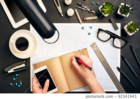 Concept architects. Architects workplace, architectural project, blueprints, ruler. Engineer holds a pen and writes in a notebook. Equipment architects on the desk with a blueprint in the office. 92341943