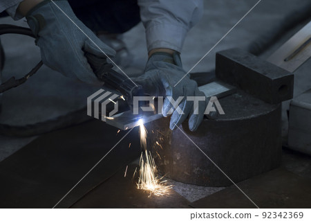 Men's hands cutting metal with a plasma cutting machine 92342369