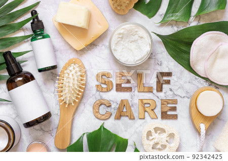 Self Care text near cosmetics, skincare accessories and monstera leaves, mockup Self Care text near cosmetics, skincare accessories and monstera leaves, mockup 92342425