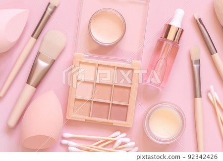 Natural beige eye shadow and decorative cosmetics on light pink, top view Natural beige eye shadow and decorative cosmetics on light pink, top view 92342426