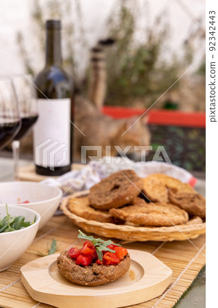 Tipical summer south Italian appetizer Friselle with cherry tomatoes, oil and rucola served outdoor 92342443