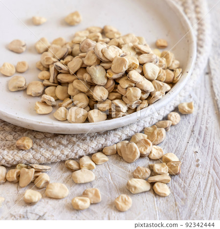 Plate of raw dry Grass pea close up on wooden table. Legumes known in Italy as Cicerchia Plate of raw dry Grass pea close up on wooden table. Legumes known in Italy as Cicerchia 92342444