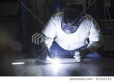 Welder image TIG welding Middle male worker who wears air-conditioning work clothes and welds 92342524