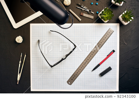 Top view of the builder's workplace, ruler, paper for drawings, compasses, glasses, tablet 92343100