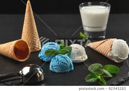 Close-up shot of a creamy and blueberry ice cream served on a dark slate, black background. Close-up shot of a creamy and blueberry ice cream served on a dark slate, black background. 92343281