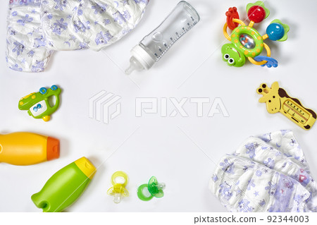 Set of accessories for baby. Pacifier, bottle, diaper, cream on white background. 92344003