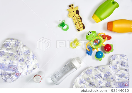 Set of accessories for baby. Pacifier, bottle, diaper, cream on white background. 92344010