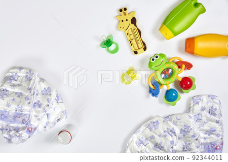 Set of accessories for baby. Pacifier, bottle, diaper, cream on white background. 92344011