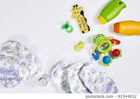 Set of accessories for baby. Pacifier, bottle, diaper, cream on white background. 92344012
