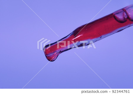 Pipette with dragon's blood. Highlighted on a lilac background, the colors of the year 2022. The concept of blood analysis for cosmetology. An ingredient of natural cosmetics. High quality photo Pipette with dragon's blood. Highlighted on a lilac background, the colors of the year 2022. The concept of blood analysis for cosmetology. An ingredient of natural cosmetics. High quality photo 92344761