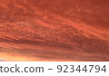Abstract dark red background. Dramatic red sky. Red sunset with clouds. Fantastic sunset background with copy space for design. Halloween, armageddon, apocalypse, end of the world concept. 92344794