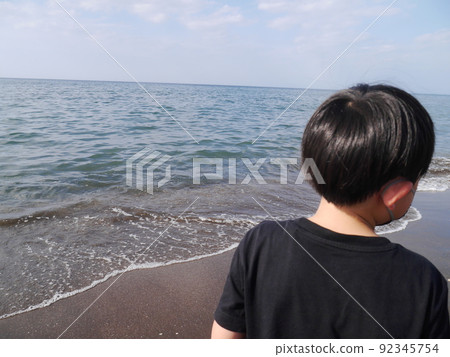 Boy looking at the sea (back view) Boy looking at the sea (back view) 92345754
