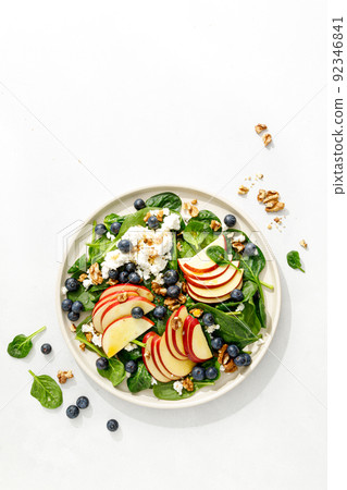 Apple and spinach fresh sweet fruit salad with blueberry, cheese cottage and walnuts, top view Apple and spinach fresh sweet fruit salad with blueberry, cheese cottage and walnuts, top view 92346841