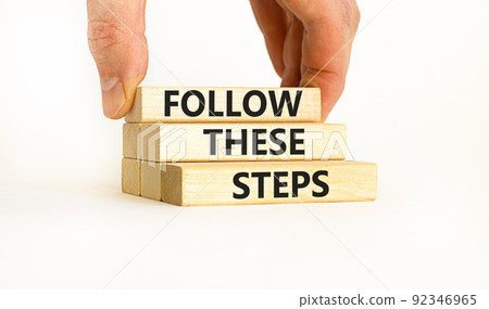 Follow these steps symbol. Concept words Follow these steps on wooden blocks. Businessman hand. Beautiful white table white background. Business and follow these steps concept. Copy space. Follow these steps symbol. Concept words Follow these steps on wooden blocks. Businessman hand. Beautiful white table white background. Business and follow these steps concept. Copy space. 92346965