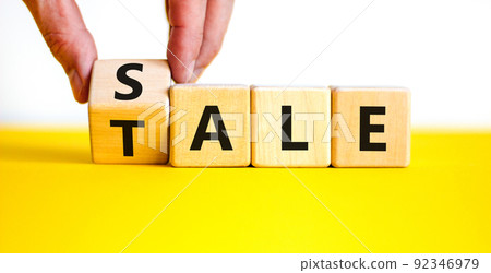 Sale or tale symbol. Businessman turns a wooden cube and changes the concept word Tale to Sale. Beautiful yellow table white background, copy space. Business and sale or tale concept. 92346979