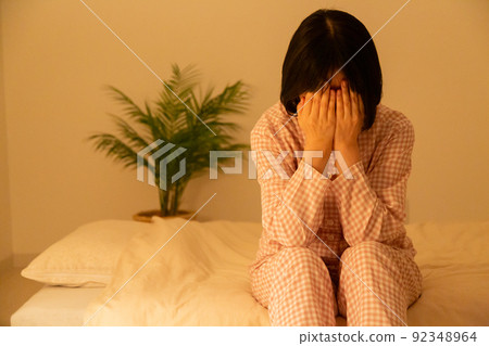Middle-aged woman in pajamas depressed in the bedroom Middle-aged woman in pajamas depressed in the bedroom 92348964