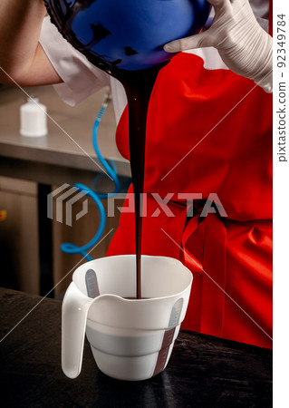 Step-by-step preparation of black designer candies. Preparation of chocolate glaze decorations for candy. 92349784