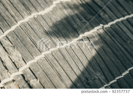 Old woven bamboo rug, rough texture dirty, fragment banner. Diagonal horizontal vertical lines, contrast shadow. Copy space for text. Abstract background. Light brown beige grey tones more in stock 92357737