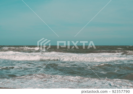 Ocean storm waves dramatically crashing splashing. Sky horizon line. Sea water edge, nature front view marine wallpaper, design. Bad weather cloudy overcast. Dark green turquoise blue tone pale matte 92357790
