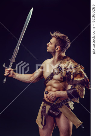 Portrait of handsome muscular gladiator with sword. Isolated. Studio shot. Portrait of handsome muscular gladiator with sword. Isolated. Studio shot. 92360269