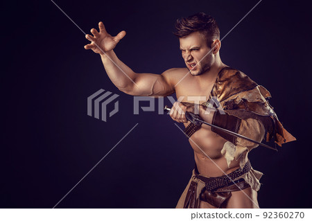 Portrait of handsome muscular gladiator with sword. Isolated. Studio shot.  92360270