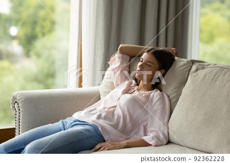Young attractive woman fell asleep to the music on sofa Young attractive woman fell asleep to the music on sofa 92362228