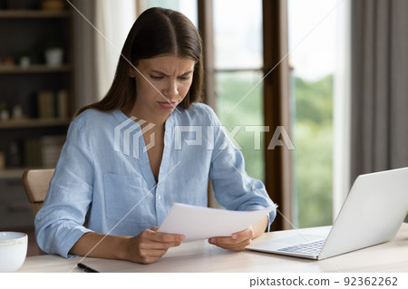 Woman read letter with bad news looks dissatisfied 92362262