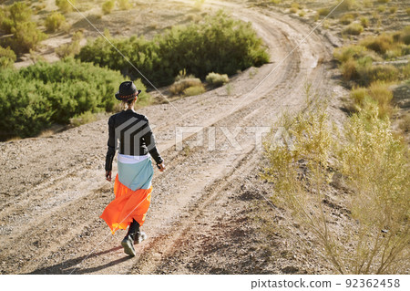 rear view of an beautiful asian woman walking on dirt road in gobi desert rear view of an beautiful asian woman walking on dirt road in gobi desert 92362458