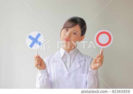 White coat woman who is worried about 〇 or X 1 92363859
