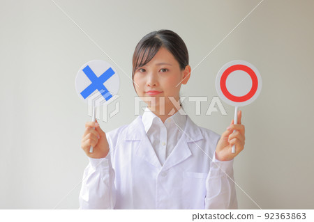 White coat woman who is worried about 〇 or X 2 92363863