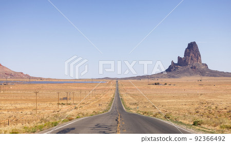 Scenic Road in the Dry Desert with Red Rocky Mountains in Background. 92366492